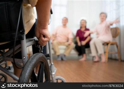 Close-up of senior woman in wheelchair with her caregiver in background and elderly friends are waiting to welcome