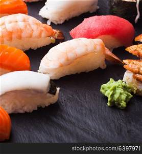 Close-up of set of four sushi with salmon, tuna, scallop and shrimp on a black background. Set of four sushi