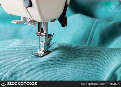 Close up of sewing machine working with turquoise fabric. sewing machine and turquoise fabric