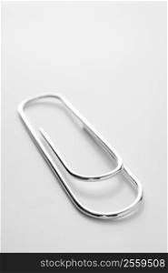 Close Up Of Silver Paperclip Against A White Background