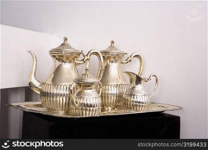 Close-up of silver teapots with sugar bowls in a tray