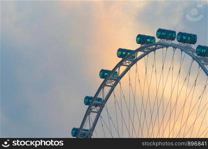Close up of Singapore flyer, a ferris wheel, located in Singapore City Downtown with sunset sky.