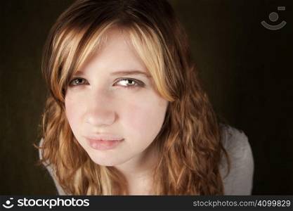 Close up of skeptical teenage girl on green background