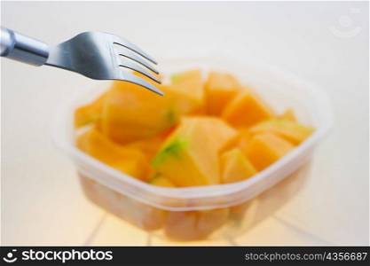 Close-up of slices of papaya with a fork