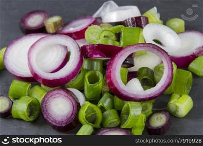 Close up of slices of purple and green scallions, green onion, spring onion, salad onion, table onion, green shallot, onion stick, long onion, baby onion, precious onion, yard onion, gibbon, syboe or scally onion.
