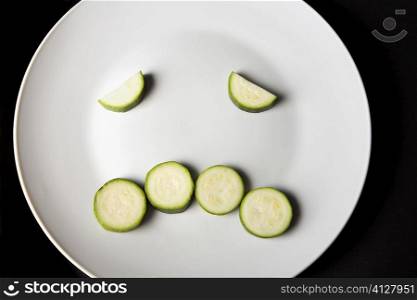 Close-up of slices of zucchini in a plate making a frowning face