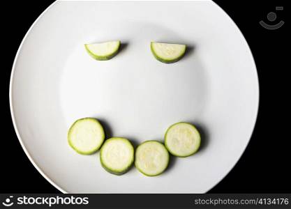 Close-up of slices of zucchini in a plate making a smiling face