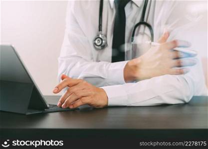 close up of smart medical doctor working with digital tablet computer and stylus pen and stethoscope on dark wooden desk with glass reflected view