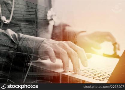 close up of smart medical doctor working with laptop computer and mobile phone and stethoscope on dark wooden desk with London city exposure