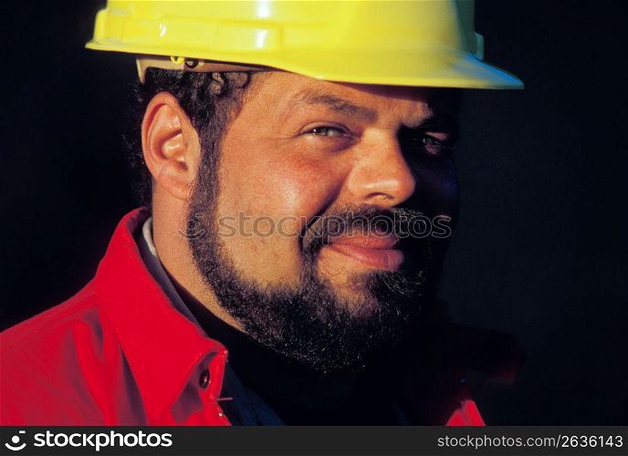 Close up of smiling, bearded construction worker wearing hard-hat