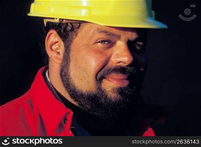 Close up of smiling, bearded construction worker wearing hard-hat