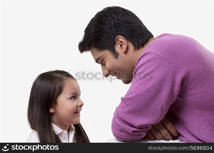 Close-up of smiling father and daughter looking at each other