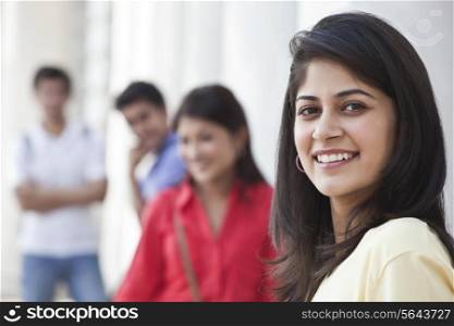 Close-up of smiling woman with friends in the background