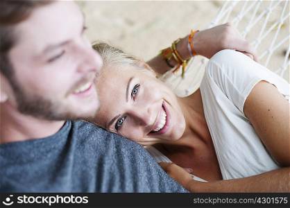 Close up of smiling young couple on beach hammock