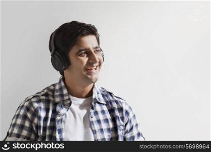 Close-up of smiling young man enjoying music