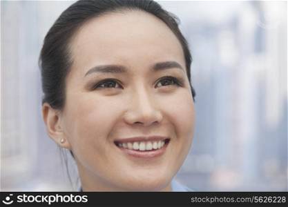 Close-up of smiling young woman looking up