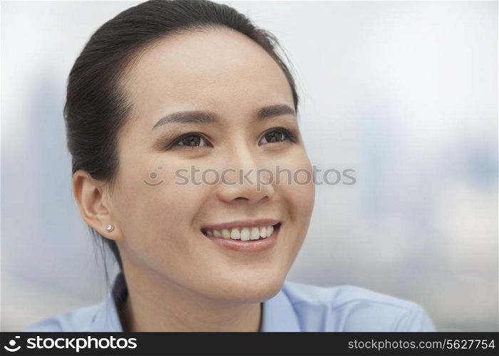 Close-up of smiling young woman looking up