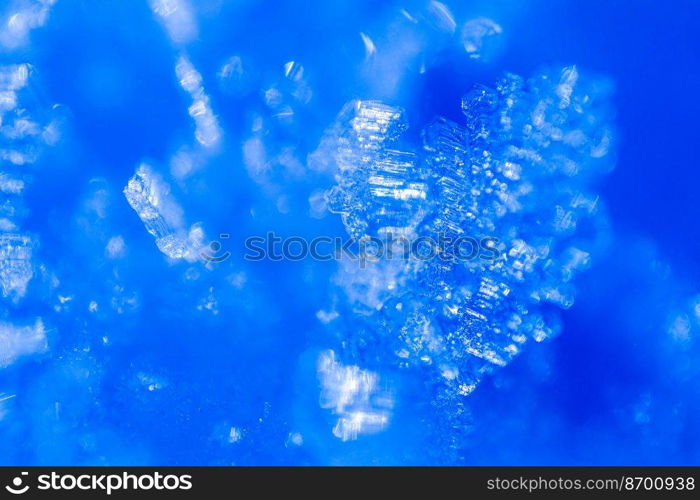 Close up of snow crystals illuminated by blue sunlight. Winter background. Macro of real snowflake  large stellar dendrites with hexagonal symmetry, long elegant arms and thin, transparent structures.. Close up of snow crystals illuminated by blue sunlight. Winter background. Macro of real snowflake  large stellar dendrites with hexagonal symmetry, long elegant arms and thin, transparent structures