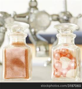 Close-up of soap powder and bath pearls in glass bottles