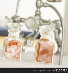 Close-up of soap powder and bath pearls in glass bottles