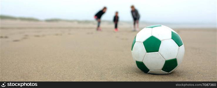 Close up of soccer ball with three people in the background. Close up of soccer ball with three people