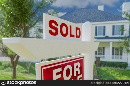 Close-up of Sold Placard On House For Sale Real Estate Sign In Front of New House.