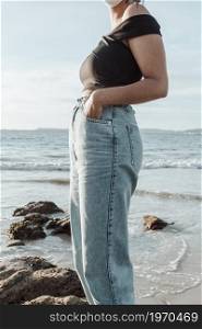 Close up of some mom jeans on a young woman during a sunny day at the beach with copy space