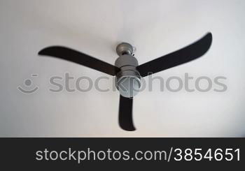 close up of spinning fan on white ceiling