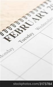 Close up of spiral bound calendar displaying month of February.
