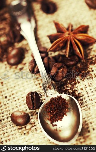 Close up of spoon, coffee beans and spices on cloth sack