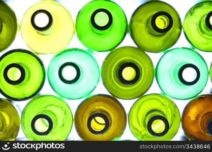 close-up of stack of various wine bottles, backlited