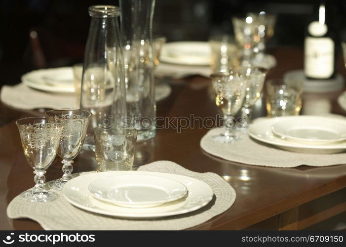 Close-up of stem glasses and plates on a dining table