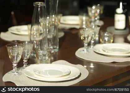Close-up of stem glasses and plates on a dining table