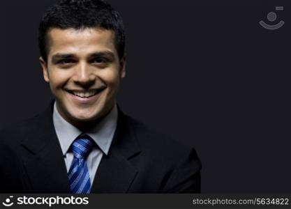 Close-up of successful business man smiling over black background