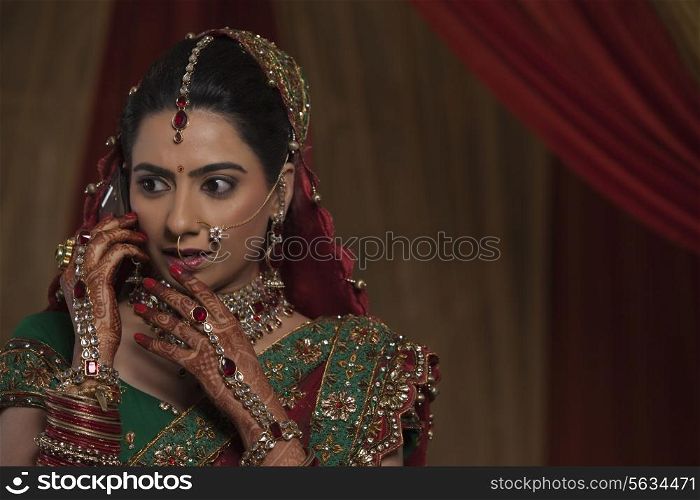 Close up of surprised young bride while talking on mobile phone