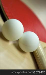 Close-up of table tennis balls with a table tennis racket