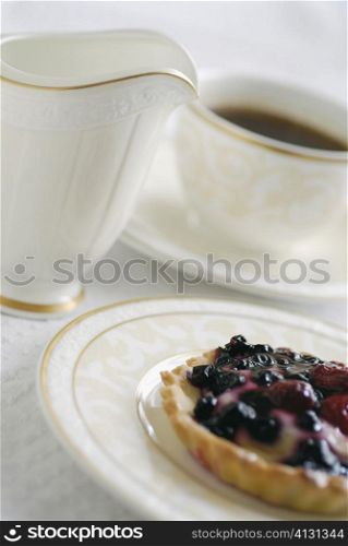 Close-up of tart with a cup of coffee