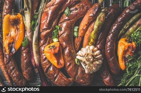 Close up of tasty grilled sausages and roasted vegetables. Top view. Barbecue grill party plate from above