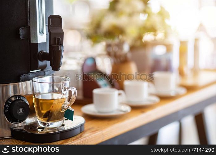 Close-up of tea from coffee machine and coffee cup on the dining table decoration at hotel