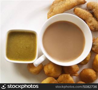 Close-up of tea with bhajiyas and sauce