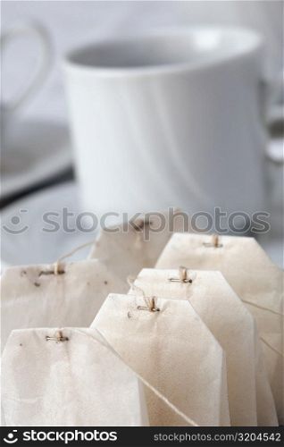 Close-up of teabags beside a cup