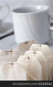 Close-up of teabags beside a cup