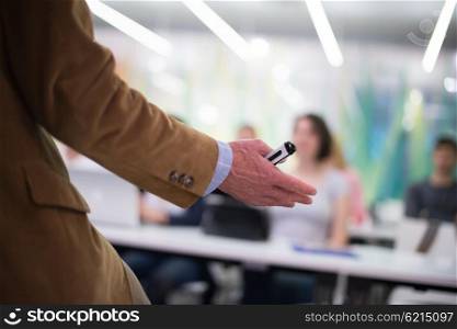 close up of teacher hand with marker while teaching lessons in school classroom to students