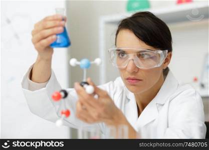 close up of technician working with erlenmeyer flask in laboratory