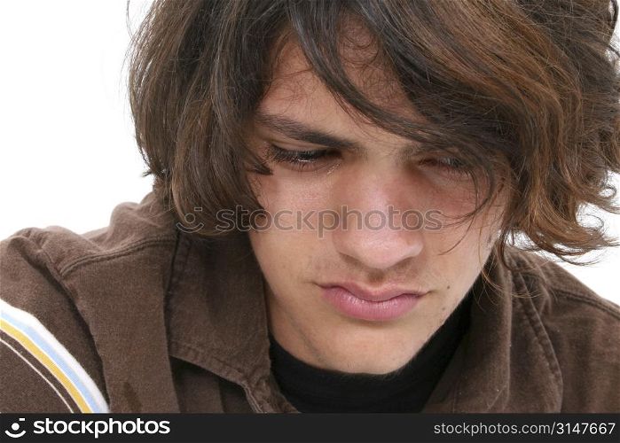 Close up of teen boy crying. Tears in eyes and on cheeks.
