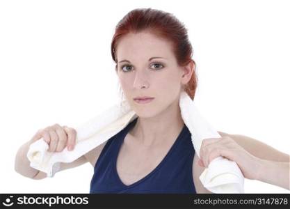 Close-up of teen girl in workout top with white towel. 17 year old girl with long red hair over white.