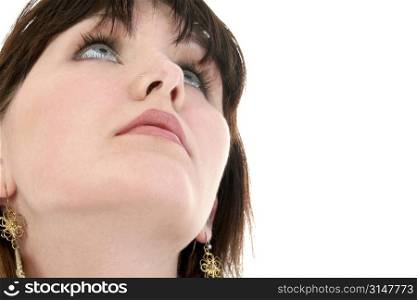 Close up of teen girl looking up over white background.