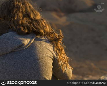 Close-up of teenage girl sitting on rock, Makhtesh Ramon, Negev Desert, Israel