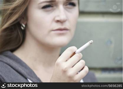 Close Up Of Teenage Girl Smoking Cigarette Outdoors