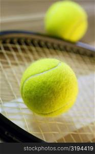 Close-up of tennis balls with a tennis racket
